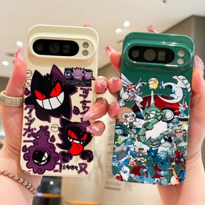 May include: Two phone cases, one cream-colored and one green, are displayed. The cream case features a purple and black cartoon character design with Japanese text. The green case showcases a colorful array of cartoon characters. Both cases have camera cutouts.