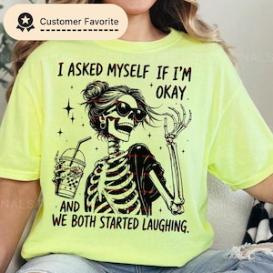 Può includere: T-shirt giallo neon con uno scheletro con occhiali da sole e una bevanda. La maglietta ha il testo "Mi sono chiesto se sto bene, ed entrambi abbiamo iniziato a ridere". Il design è in bianco e nero.