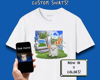 Può includere: Una t-shirt bianca con una stampa grafica di un computer, un piccolo cane bianco e pesci pagliaccio. Il testo CUSTOM SHIRTS! appare in alto e NOW IN 11 COLORS! è in un riquadro. Uno smartphone mostra il testo YOUR PHOTO! sopra un cane.