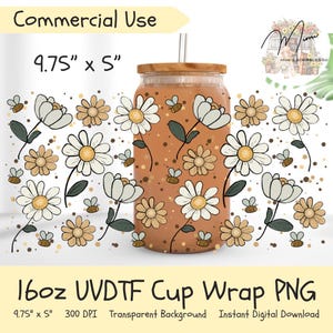 Peut inclure: Un design PNG d'emballage de gobelet de 16 oz avec un motif floral de marguerites et d'abeilles en blanc, beige et marron. L'image comprend le texte "Commercial Use" et des dimensions de 24,77 cm x 12,7 cm.