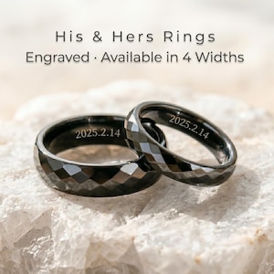 May include: Two black faceted rings, each engraved with the date "2025.2.14", rest on a white stone. The image features rings from a "His & Hers Rings" collection, available in four widths.