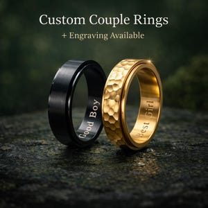 Puede incluir: Dos anillos de pareja personalizados. Uno es negro con la inscripción "Good Boy", y el otro es dorado con la inscripción "Best Girl". El anillo dorado tiene una superficie texturizada. El texto "Custom Couple Rings + Engraving Available" está en la parte superior.