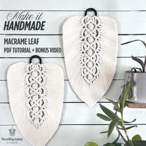Peut inclure: Deux décorations murales en macramé en forme de feuille, de couleur crème, avec des anneaux en métal noir. Les feuilles présentent un motif central détaillé. Le texte indique "Make it Handmade" et "Macrame Leaf PDF Tutorial + Bonus Video".