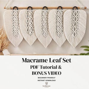 May include: A set of five cream-colored macrame leaf decorations hanging from a wooden rod with black metal rings. Each leaf features intricate knotted patterns down the center. The text "Macrame Leaf Set" and other details are visible.