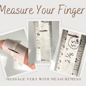 Może przedstawiać: Obraz pokazujący, jak zmierzyć palec pod pierścionek. Tekst "Measure Your Finger" znajduje się na g&oacute;rze. Obraz przedstawia palec owinięty papierem, z pomiarami w calach i centymetrach. Tekst "MESSAGE VERA WITH MEASUREMENT" znajduje się na dole.
