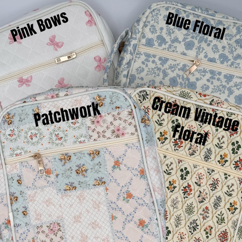 May include: Four quilted cosmetic bags with different patterns. One is white with pink bows and the text "Pink Bows". Another is blue with a floral pattern and the text "Blue Floral". The third is patchwork with the text "Patchwork". The last is cream with the text "Cream Vintage Floral".