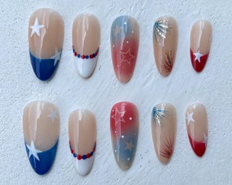 Unhas postiças francesas patrióticas nas cores vermelho, branco e azul, com as cores dos EUA. Unhas para o Dia da Memória, 4 de julho, com estrelas e fogos de artifício.