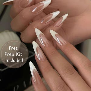 Pode incluir: Unhas artificiais longas em forma de amêndoa com um design clássico de manicure francesa. As unhas apresentam uma ponta branca e uma base transparente de aspeto natural. A imagem inclui o texto "Free Prep Kit Included".
