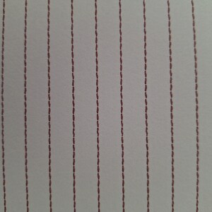 以下が含まれることがあります： 小さなダークレッドの破線ステッチで構成された垂直線の繰り返しパターンが特徴の明るい色の生地。質感は滑らかで均一に見え、一貫したステッチパターンが表面全体に平行に走っています。