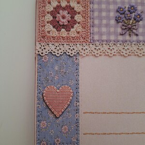 May include: A decorative stationery card featuring a patchwork design with a crochet-style square, a purple gingham panel with a floral bouquet, a lace trim, and a blue floral strip with a pink heart appliqu&eacute;, alongside lined writing space.