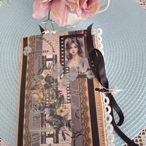 Agenda a righe misure 20cm x 14 cm. Copertina e retro decorata con pizzo,nappine,nastro,adesivi e perline all'interno ogni pagina è decorata
