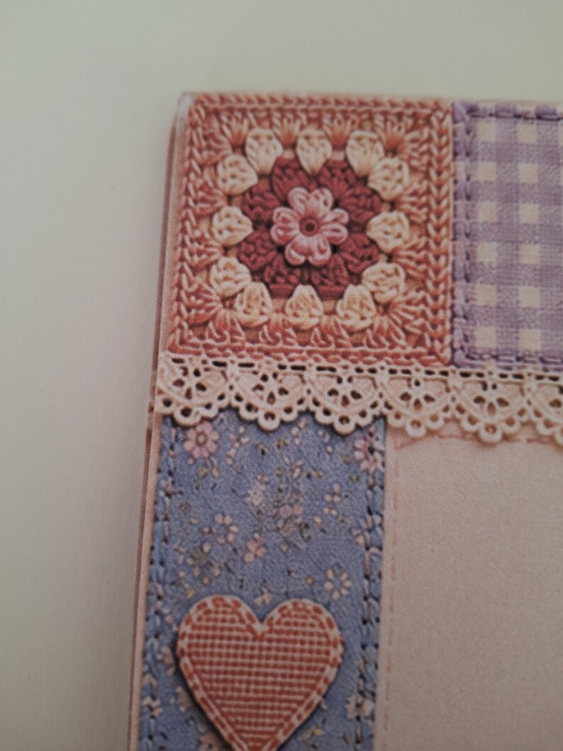 May include: A rectangular card featuring a patchwork design with a square crochet motif in shades of pink and cream, a purple gingham square, and a blue floral panel. A cream-coloured lace trim separates the sections, and a pink heart is attached.