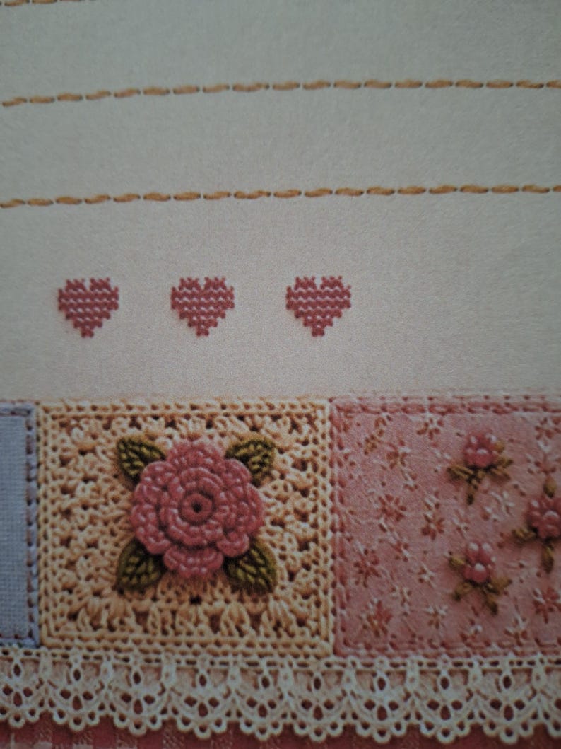Puede incluir: Una pieza textil con puntadas horizontales de color canela sobre tres peque&ntilde;os corazones rosas bordados en punto de cruz. Debajo, un motivo cuadrado de ganchillo con una rosa rosa y hojas verdes junto a una tela floral rosa con encaje.