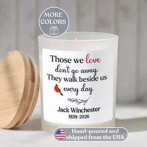 May include: A white candle with a wooden lid, featuring the text "Those we love don't go away. They walk beside us every day." A red cardinal illustration is included. The candle is personalized with a name and dates.