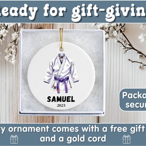 May include: White ceramic ornament featuring a detailed illustration of a karate uniform with a purple belt. The ornament is personalized with the name "SAMUEL" and the year "2025". The text "Ready for gift-giving" is at the top.