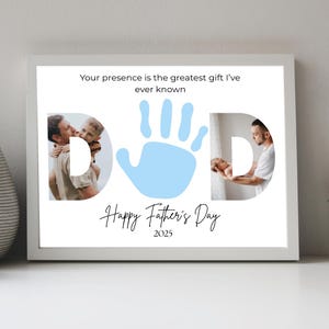 May include: A framed print with the word "DAD" formed by photos and a blue handprint. The text "Your presence is the greatest gift I've ever known" and "Happy Father's Day 2025" are also included.