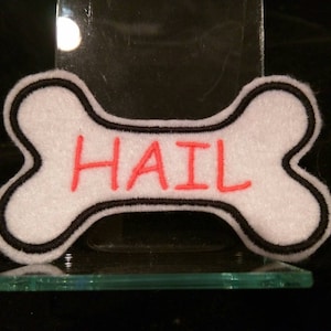 May include: White bone-shaped patch with a black outline and the word "HAIL" embroidered in red.