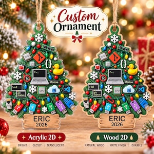 May include: Two Christmas tree-shaped ornaments featuring tech-themed icons like laptops, CPUs, USB drives, and rubber ducks. Both ornaments display the text 'ERIC 2026' on a wooden-style base. One is clear acrylic, the other is natural wood.
