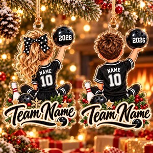 May include: Two acrylic Christmas ornaments featuring a girl with a polka dot bow and a boy, both wearing black jerseys with the number 10 and the word NAME. Each holds a black bowling ball labeled 2026 above a base with the text Team Name.