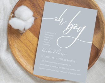 Könnte beinhalten: Eine Babyparty-Einladung mit hellblauem Hintergrund und weißem Text. Die Einladung lautet "Oh Boy!" in einer kursiv geschriebenen Schrift. Der Text enthält auch das Datum, die Uhrzeit und den Ort der Party.
