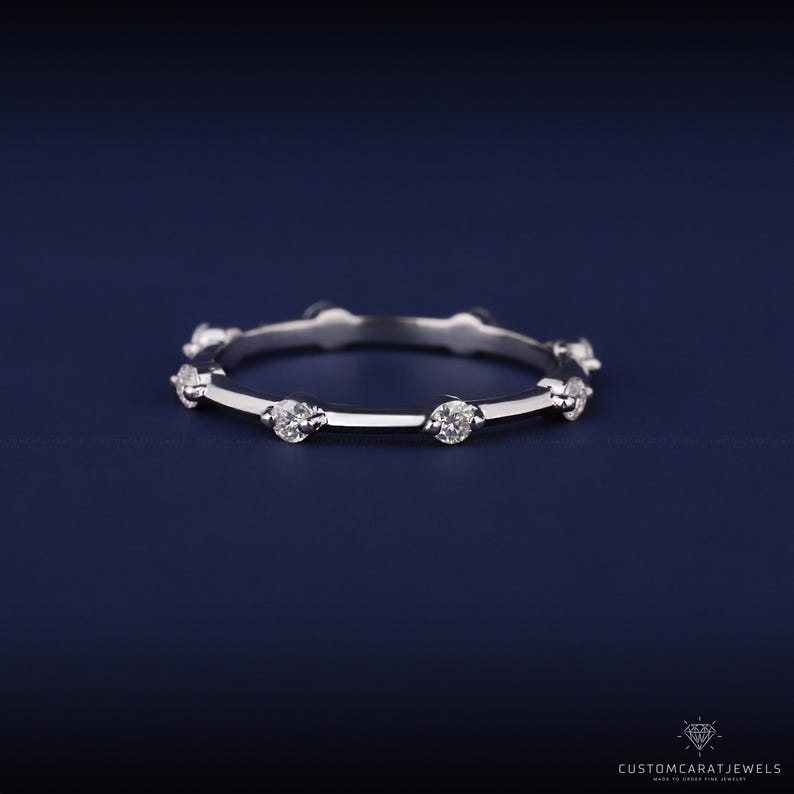 Close-up of diamond station band in 14K white gold showing precise diamond placement and polished finish.
diamond clarity, station design, white gold band, elegant sparkle, dainty ring, stacking band, wedding accessory, anniversary ring, fine jewelry, everyday elegance, bridal band, gold polish, minimalist style, subtle ring, ring detai