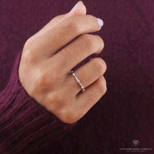 Top-down view of diamond station ring in white gold, showing symmetry and delicate brilliance.
top view ring, diamond clarity, station placement, white gold band, stacking ring, wedding band, eternity design, minimalist ring, bridal jewelry, fine accessory, elegant sparkle, subtle design, chic band, dainty elegance, classic ring