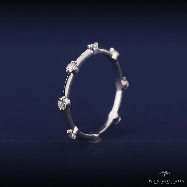 Handshot of white gold diamond station band with minimalist design, perfect for everyday wear.
hand photo ring, diamond sparkle, white gold ring, dainty style, stacking band, everyday jewelry, bridal elegance, wedding accessory, anniversary ring, fine jewelry, chic look, simple band, elegant ring, subtle sparkle, daily ring
