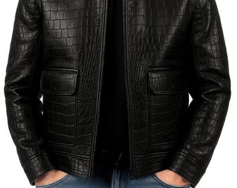 May include: Black leather jacket with a textured, crocodile-like pattern. The jacket features a collared neckline, two front pockets, and a zipper closure. The model is wearing blue jeans.