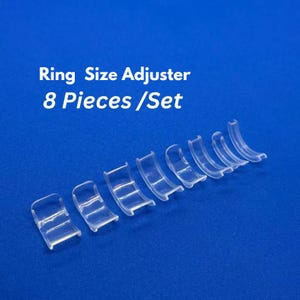 Könnte beinhalten: Acht transparente, kunststoffene Ringgrößenversteller in verschiedenen Größen.  Ring Size Adjuster 8 Pieces/Set