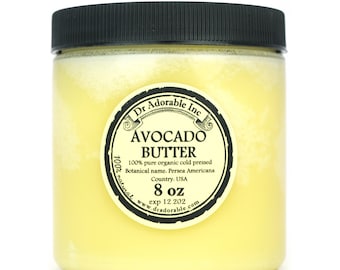 May include: A glass jar with a black lid filled with yellow avocado butter. The label reads "Dr Adorable Inc. Avocado Butter 100% pure organic cold pressed Botanical name: Persea Americana Country: USA 100% natural www.dradorable.com 8 oz exp 12.202"