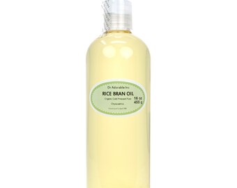 May include: A clear glass bottle of 16 ounce (455 gram) organic cold-pressed rice bran oil. The label reads "Dr Adorable Inc. Rice Bran Oil Organic Cold Pressed Pure Oryza sativa Country of origin USA."