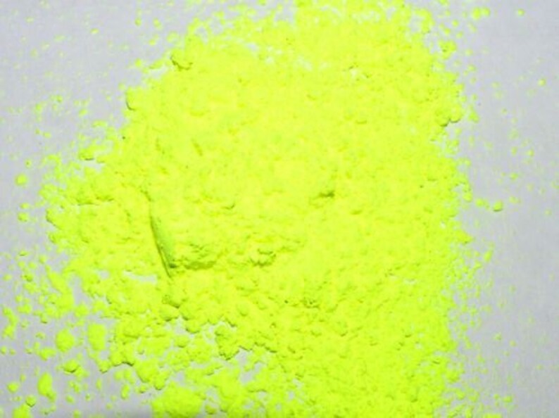 May include: A close-up of a pile of bright yellow powder. The powder is finely ground and has a uniform texture.