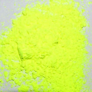 May include: A close-up of a pile of bright yellow powder. The powder is finely ground and has a uniform texture.