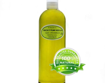 Può includere: Una bottiglia di vetro trasparente di olio di semi di fico d'India, etichettata "Dr Adorable Inc. Prickly Pear Seed Oil, organic cold pressed pure 16 oz (455 ml), Opuntia ficus indica, Country of origin USA". La bottiglia ha un'etichetta verde con un sigillo bianco che dice "Guarantee 100% Natural" con cinque stelle.