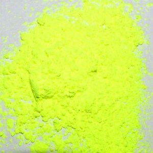 May include: A close-up of a pile of bright yellow powder. The powder is finely ground and has a uniform texture.