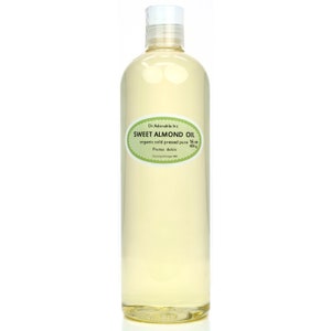May include: A clear glass bottle of organic sweet almond oil, labeled with the brand name "Dr Adorable Inc." and the text "SWEET ALMOND OIL, organic cold pressed pure 16 oz, Prunus dulcis, Country of origin USA".