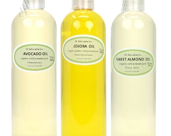 May include: Three clear glass bottles of organic cold-pressed oil. The bottles are labelled with the brand name "Dr. Adorable Inc." and the type of oil: "Avocado Oil", "Jojoba Oil", and "Sweet Almond Oil". Each bottle contains 12 fl oz (340 g) of oil.