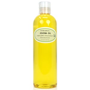 May include: A clear glass bottle filled with golden yellow jojoba oil. The label reads "Dr. Adorable Inc. JOJOBA OIL organic golden cold pressed pure 12 oz 340g Simmondsiachinensis Country of origin: Israel"