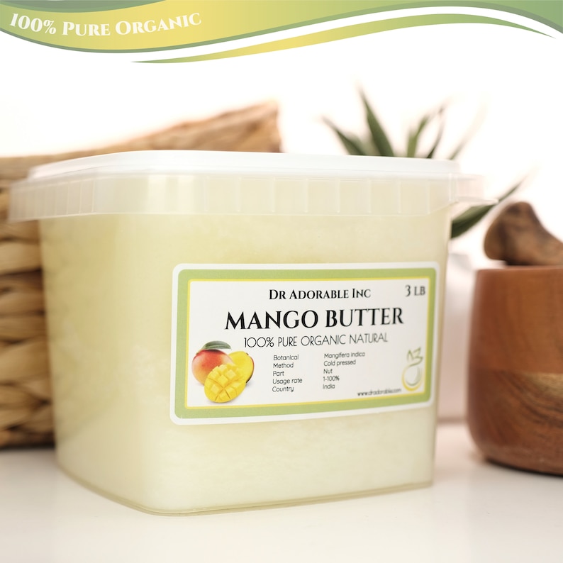 May include: A white plastic container filled with a light yellow mango butter. The container has a label that reads "Dr. Adorable Inc. 3 LB Mango Butter 100% Pure Organic Natural". The label also includes information about the botanical method, part, usage rate, and country of origin.