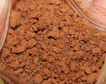 May include: Close-up of a brown cocoa powder in a clear plastic bag.
