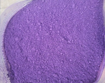 May include: Close-up of a bag filled with vibrant purple powder. The powder has a fine, granular texture and a consistent color throughout. The bag's translucent material allows the color to be fully visible.