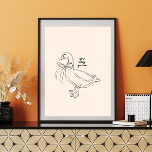 Minimalist line drawing of a goose wearing a bow, with playful handwritten text saying “you silly goose,” set on a soft cream background.
