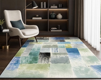 May include: A rectangular area rug featuring a patchwork design of various blue, green, gray, and white squares. The pattern displays a watercolor-like texture with varying color intensities and a small grid motif within one of the light blue squares.
