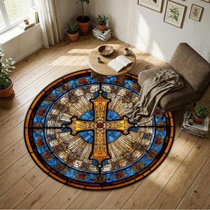 Könnte beinhalten: Runder Teppich mit Buntglas-Design, der ein goldenes Kreuz in der Mitte zeigt, umgeben von blauen und orangen Mustern. Der Teppich liegt auf einem Holzboden, mit einem Stuhl und einem kleinen Tisch in der Nähe.