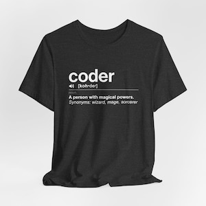 May include: A dark heather grey t-shirt with a white graphic that reads "coder" and defines the word as "a person with magical powers". The definition also includes synonyms: wizard, mage, sorcerer.