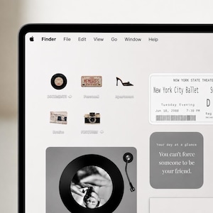 May include: A computer screen displaying a desktop interface with a top menu bar, various folder icons including a vinyl record, a license plate, a shoe, a newspaper, and a camera, plus a New York City Ballet ticket and a quote box.