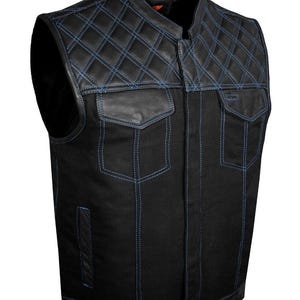 Może przedstawiać: Czarna kamizelka dżinsowa z pikowanymi skórzanymi akcentami i niebieskimi przeszyciami. Posiada dwie kieszenie na piersi i stójkę. Stylowa, bezrękawnikowa kurtka do noszenia na co dzień.