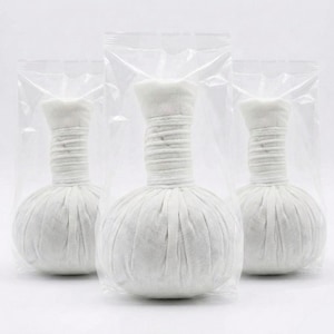 Puede incluir: Tres bolsas de masaje redondas de tela blanca con cuello cilíndrico, selladas en bolsas de plástico transparente. Las bolsas tienen un cuello texturizado y acanalado y un cuerpo esférico. Las bolsas están diseñadas para uso terapéutico.