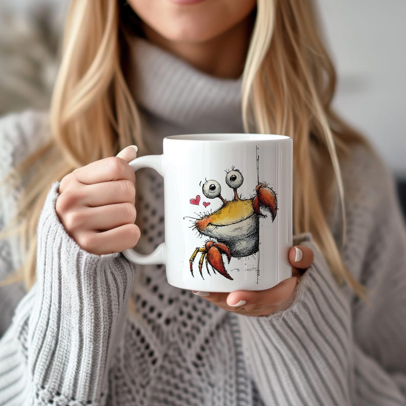 May include: White ceramic mug featuring a cartoon crab design. The crab has a yellow body, red claws, and large, googly eyes. Two small red hearts are next to the crab. The mug has a white handle.