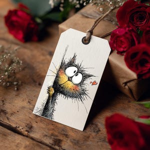May include: A gift tag with a whimsical illustration of a cartoon cat peeking around a corner. The cat is black and gray with a yellow muzzle and rosy cheeks. A small red heart is drawn next to the cat. The tag is tied with twine.